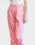 Pink leopard print pants worn by a person on a white background