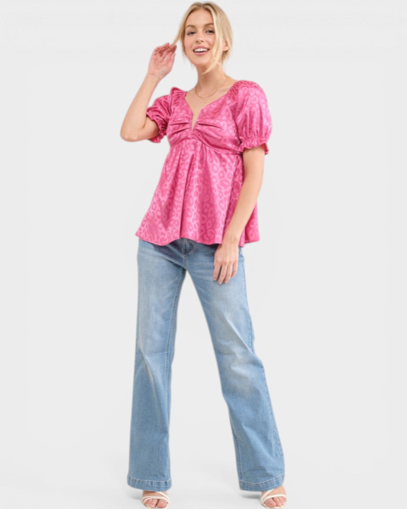 Woman wearing a pink top and blue jeans on a white background