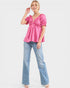 Woman wearing a pink top and blue jeans on a white background