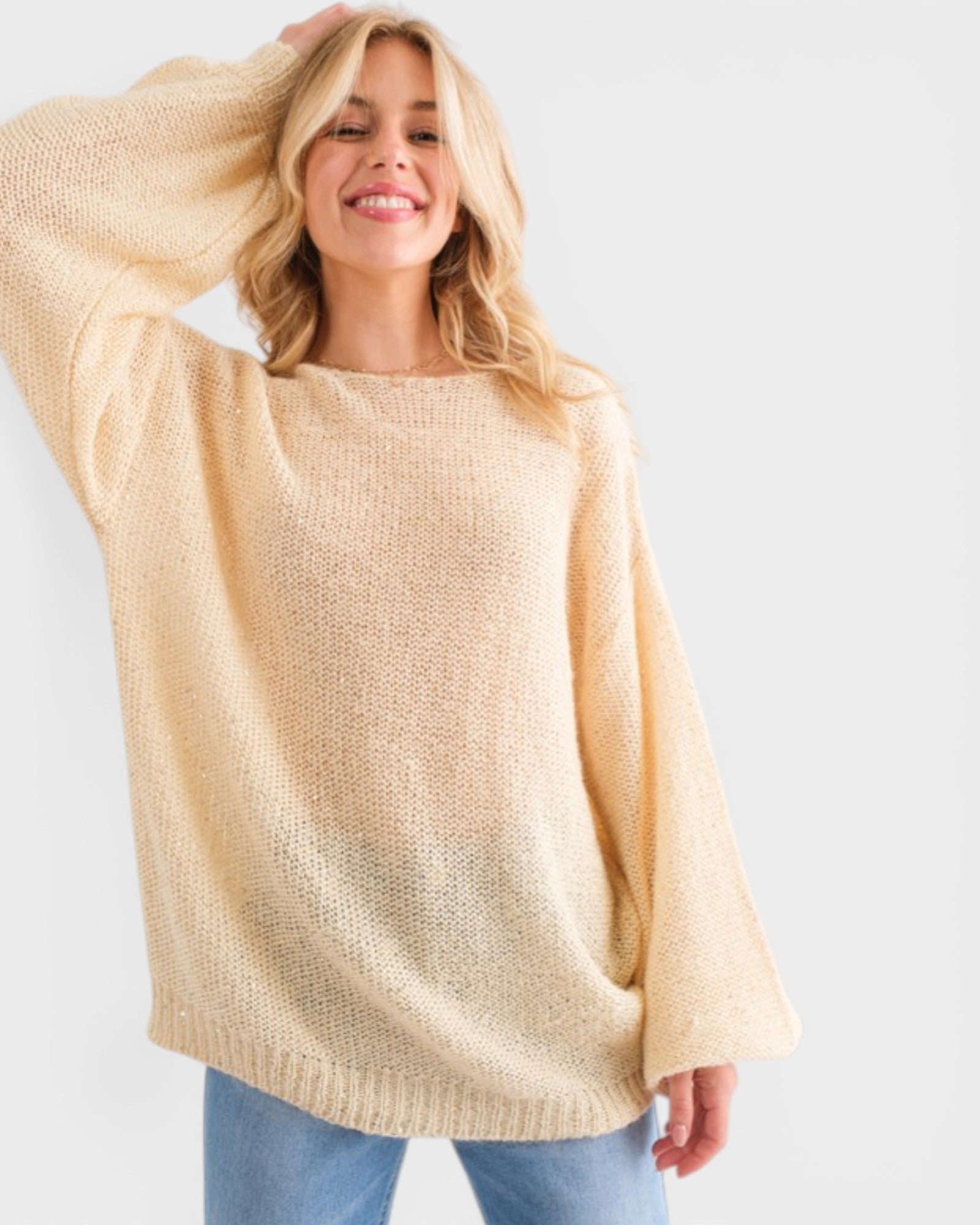 Woman wearing a beige sweater against a white background