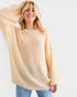 Woman wearing a beige sweater against a white background