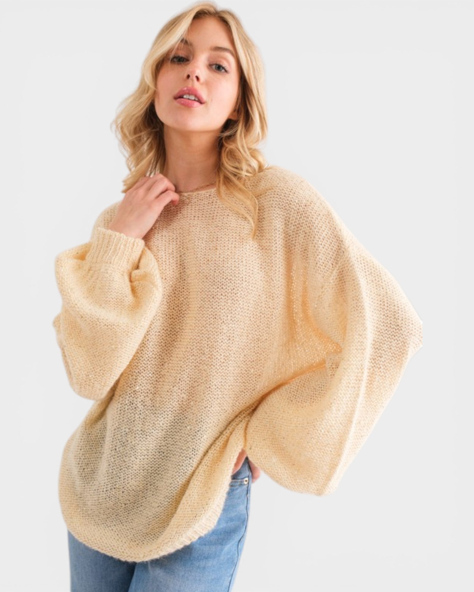 Woman wearing a beige poncho against a white background