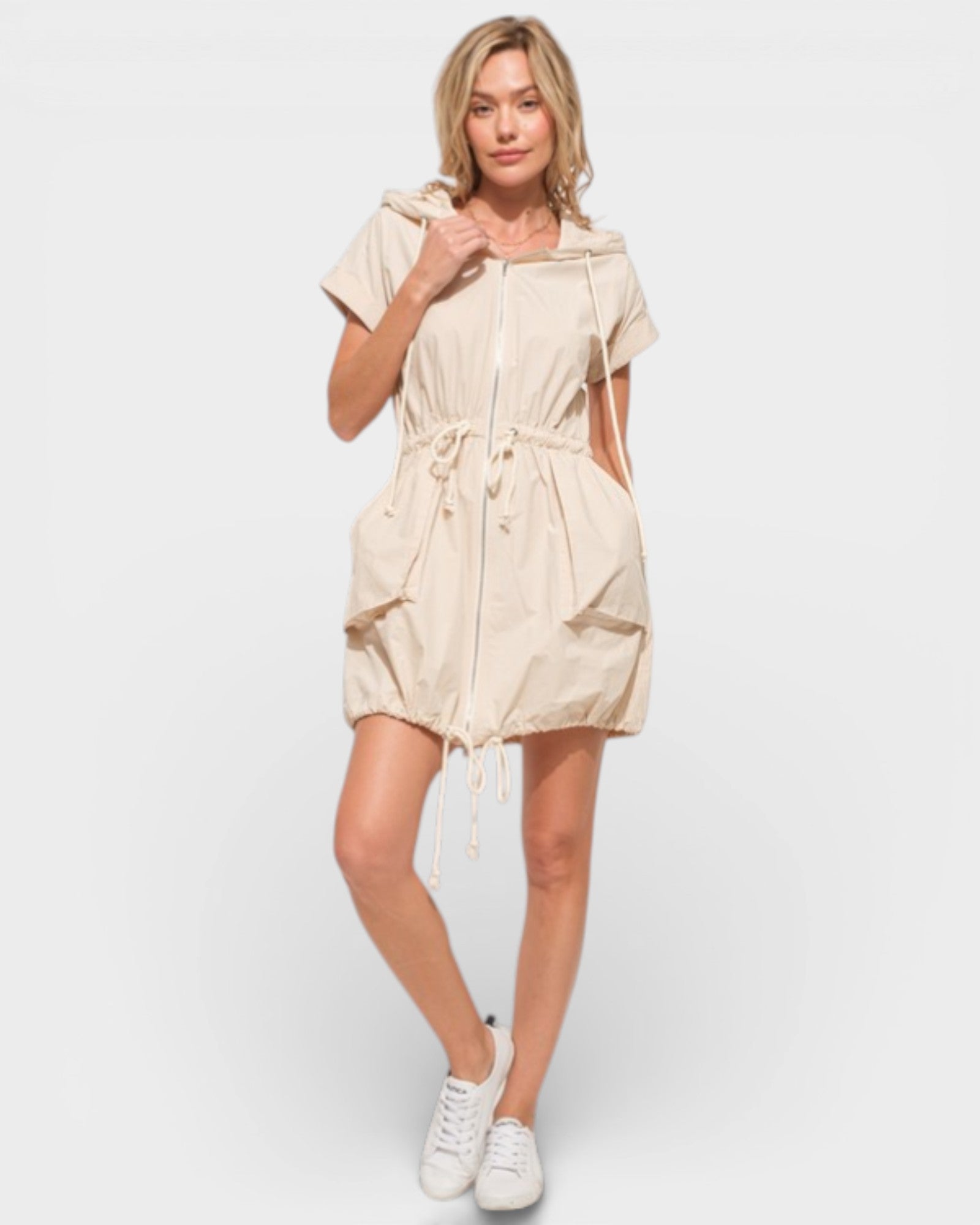 Woman wearing a beige dress with a white background