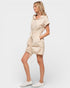 Woman wearing a beige hooded dress on a white background