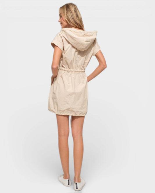 Woman wearing a beige hooded dress on a white background