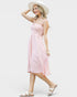 Woman wearing a pink dress and white hat on a white background