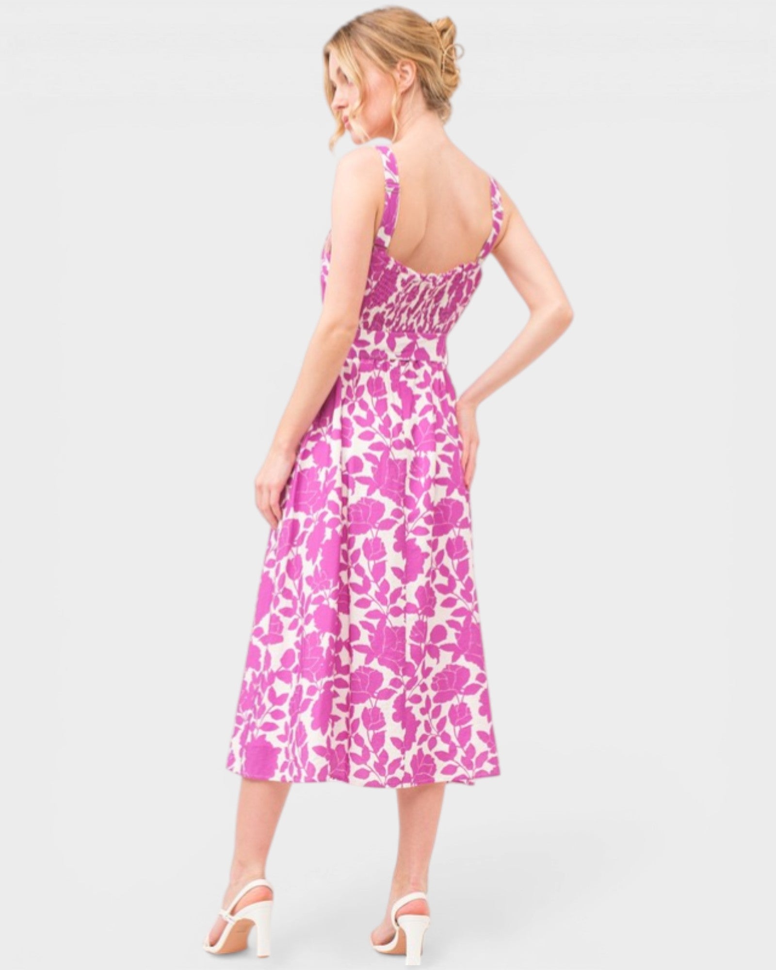 Woman wearing a pink and white patterned dress on a light gray background
