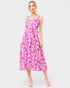 Woman wearing a pink and white patterned dress on a white background