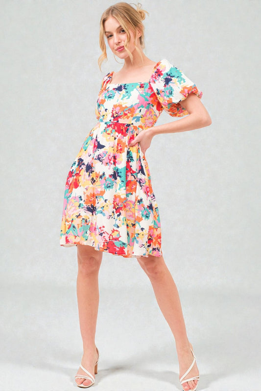 Woman wearing a colorful floral dress on a gray background