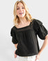Woman wearing a black blouse with ruffled sleeves on a white background