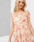 Woman wearing a floral dress against a plain background