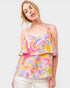 Woman wearing a colorful patterned top on a white background
