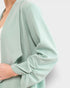 Light green sweater with long sleeves on a white background