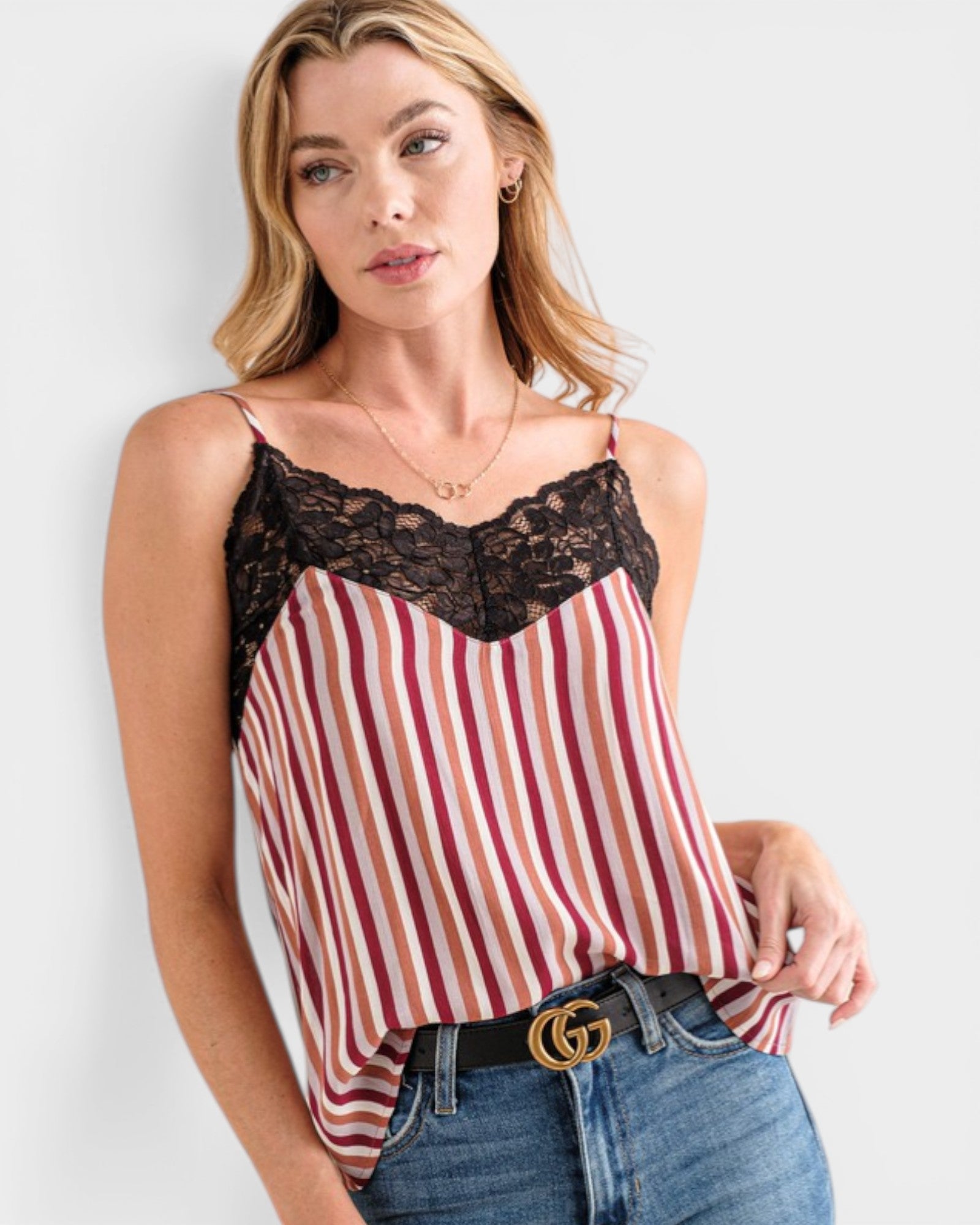 Woman wearing a striped tank top with lace detail and Gucci belt.