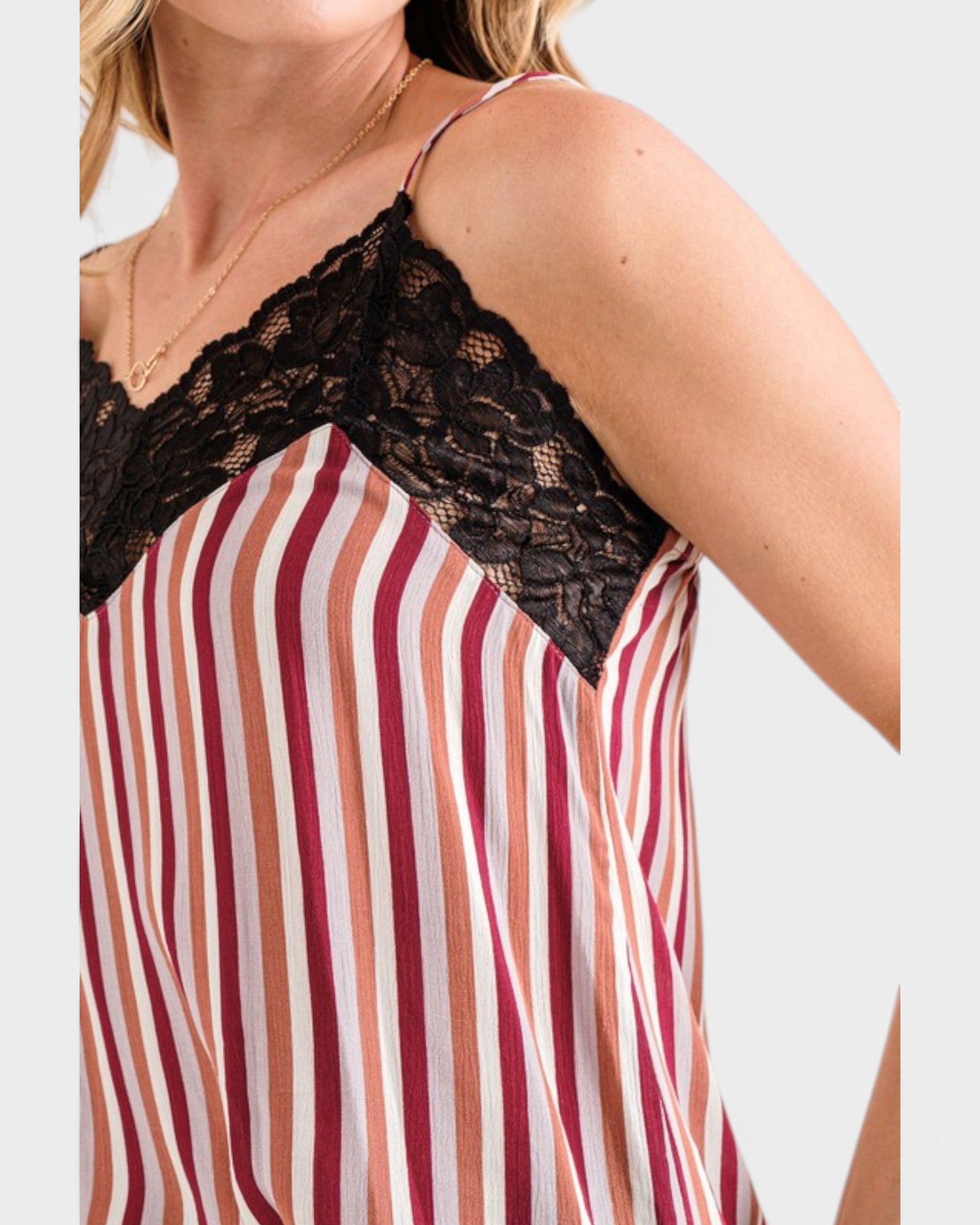 Striped top with lace detailing on a plain background