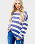 Woman wearing a blue and white striped long-sleeve top on a plain background