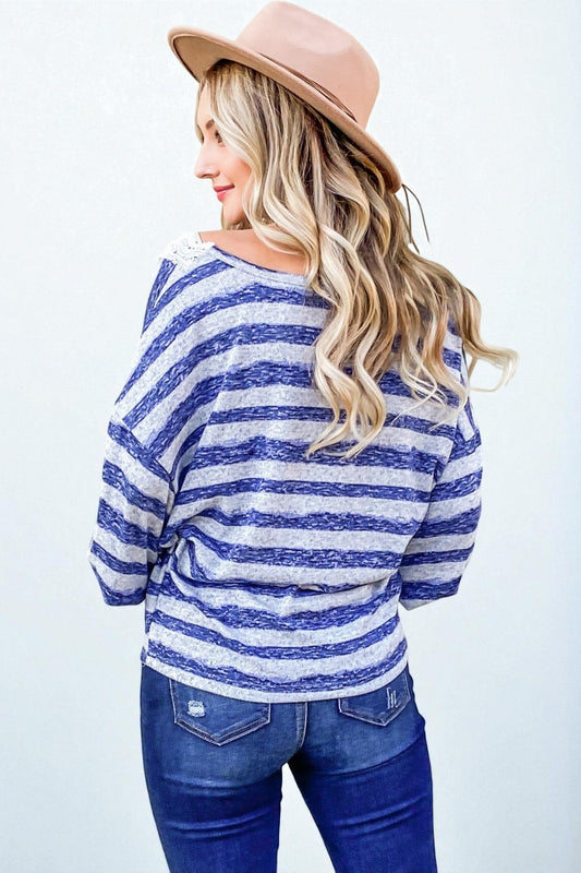 Woman wearing a blue and white striped sweater with a beige hat on a white background