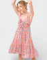 Woman wearing a colorful patterned dress on a white background