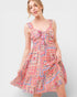 Woman wearing a colorful patterned dress on a white background