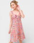 Woman wearing a colorful patterned dress on a white background