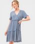 Woman wearing a blue tiered dress on a white background