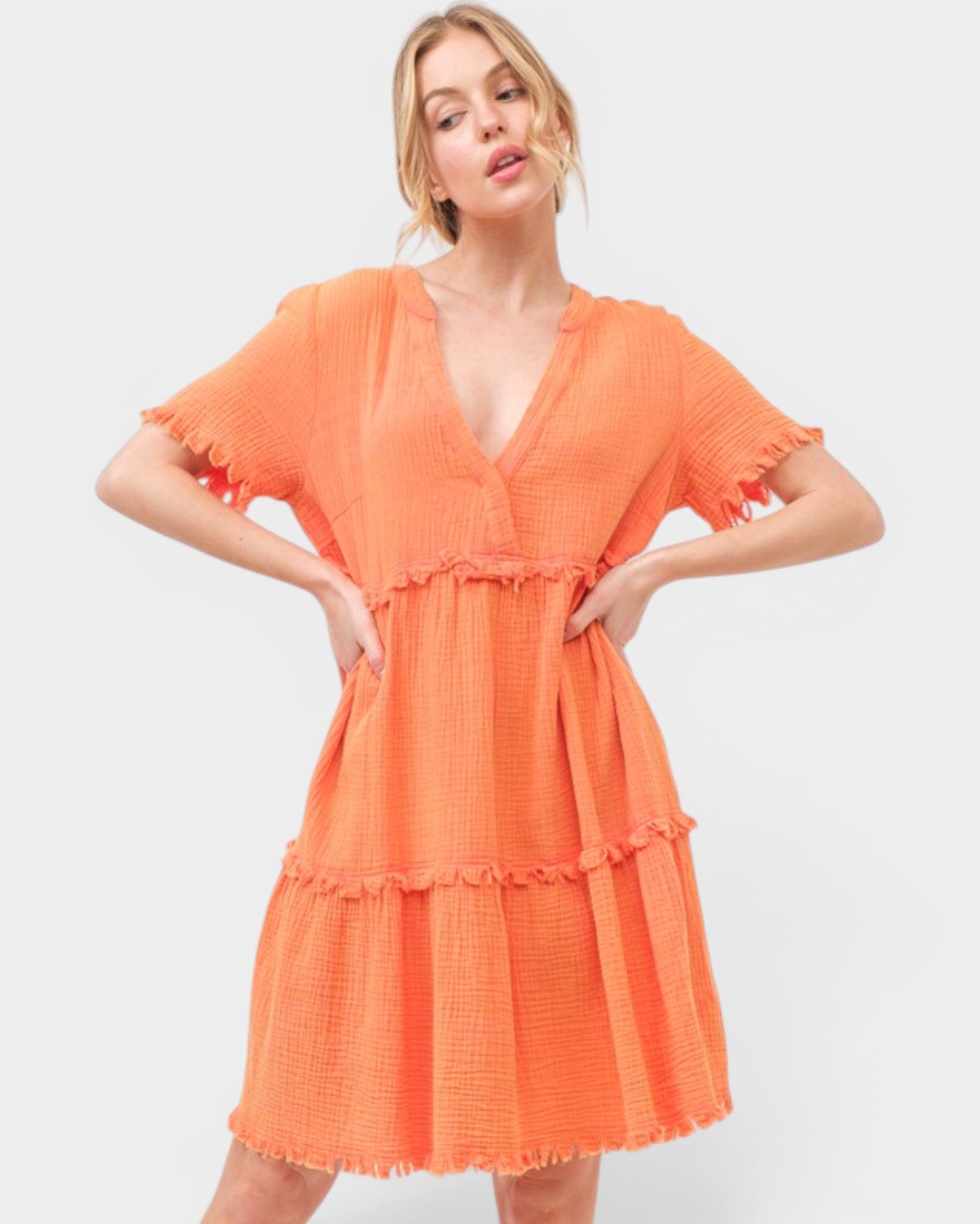 Woman wearing an orange dress against a white background