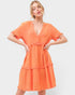 Woman wearing an orange dress against a white background