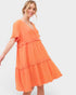 Woman wearing an orange dress on a white background