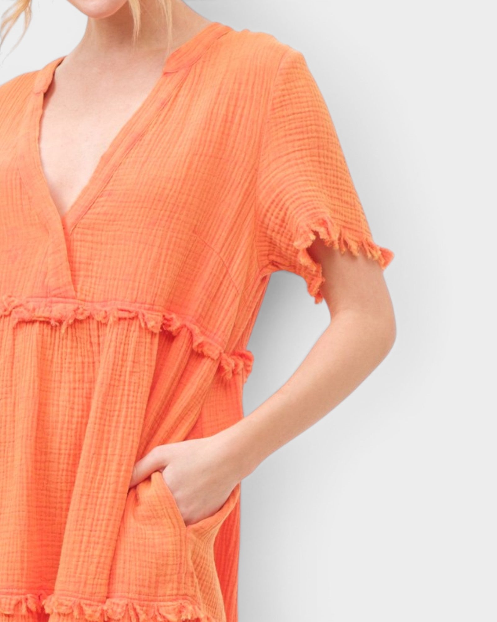 Orange dress with ruffled details on a plain background