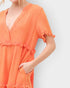 Orange dress with ruffled details on a plain background