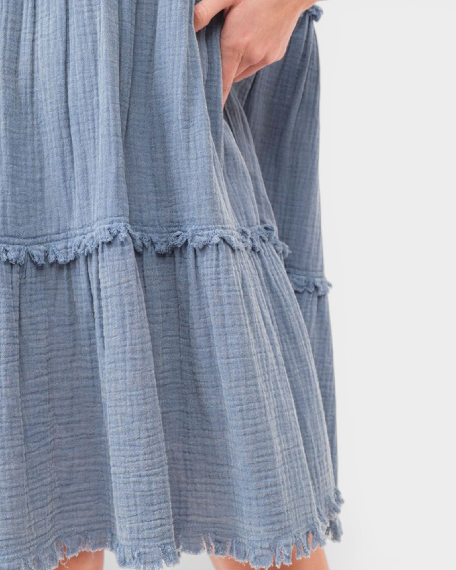 Blue textured dress with ruffled hem on a white background