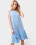 Woman wearing a light blue dress with ruffled layers on a white background