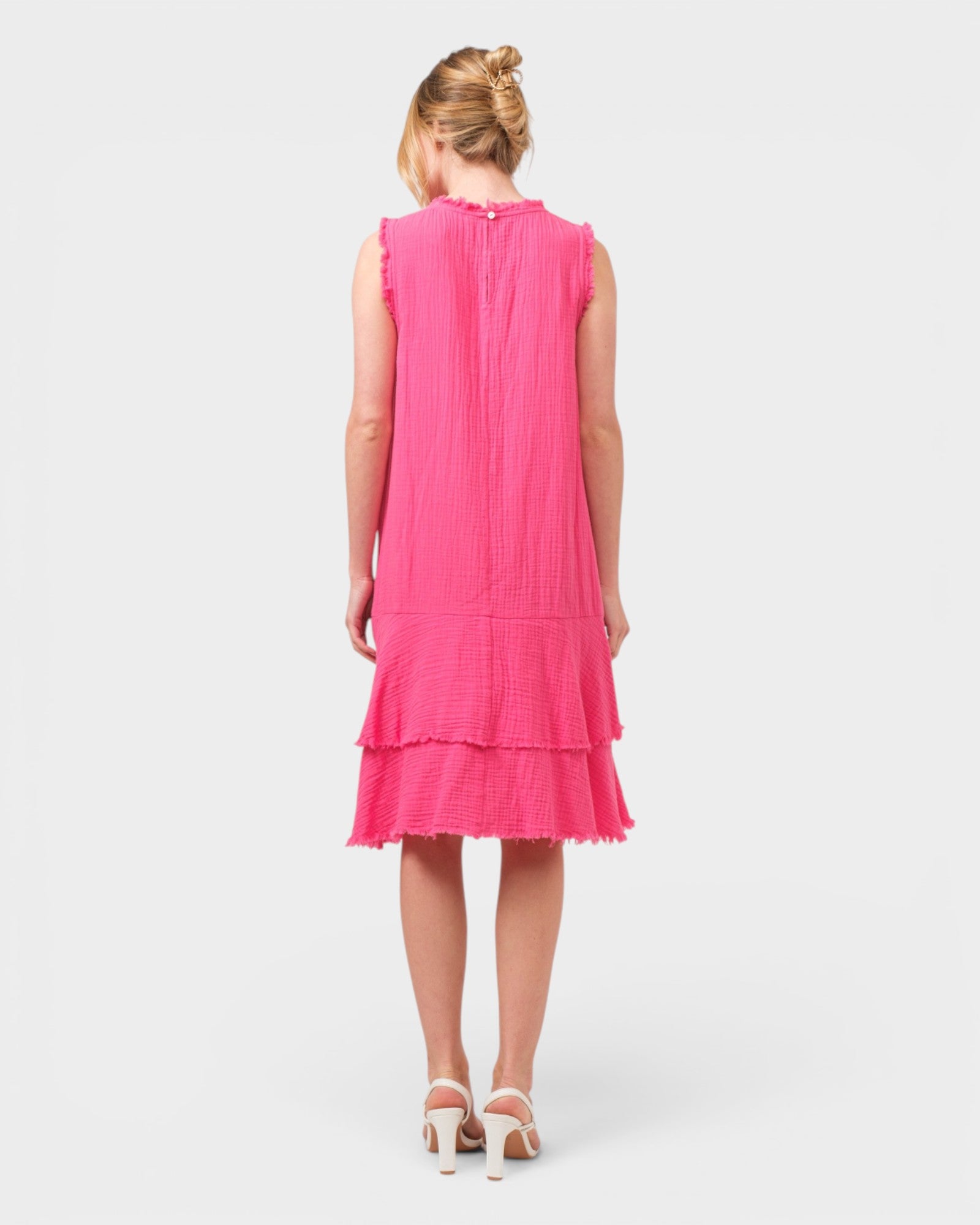 Pink dress with ruffled layers on a white background