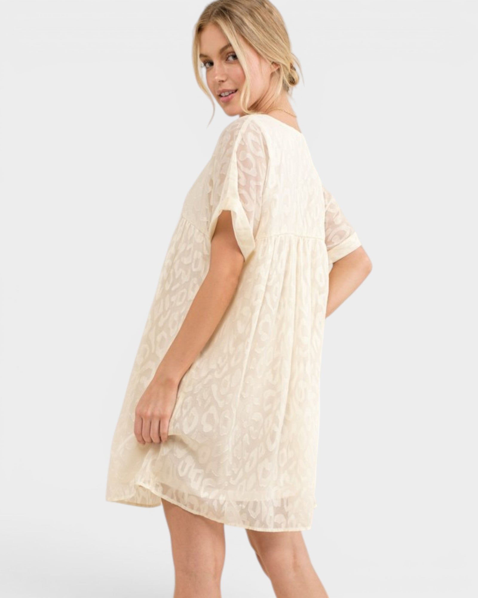 Woman wearing a beige lace dress on a white background