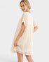 Woman wearing a beige lace dress on a white background