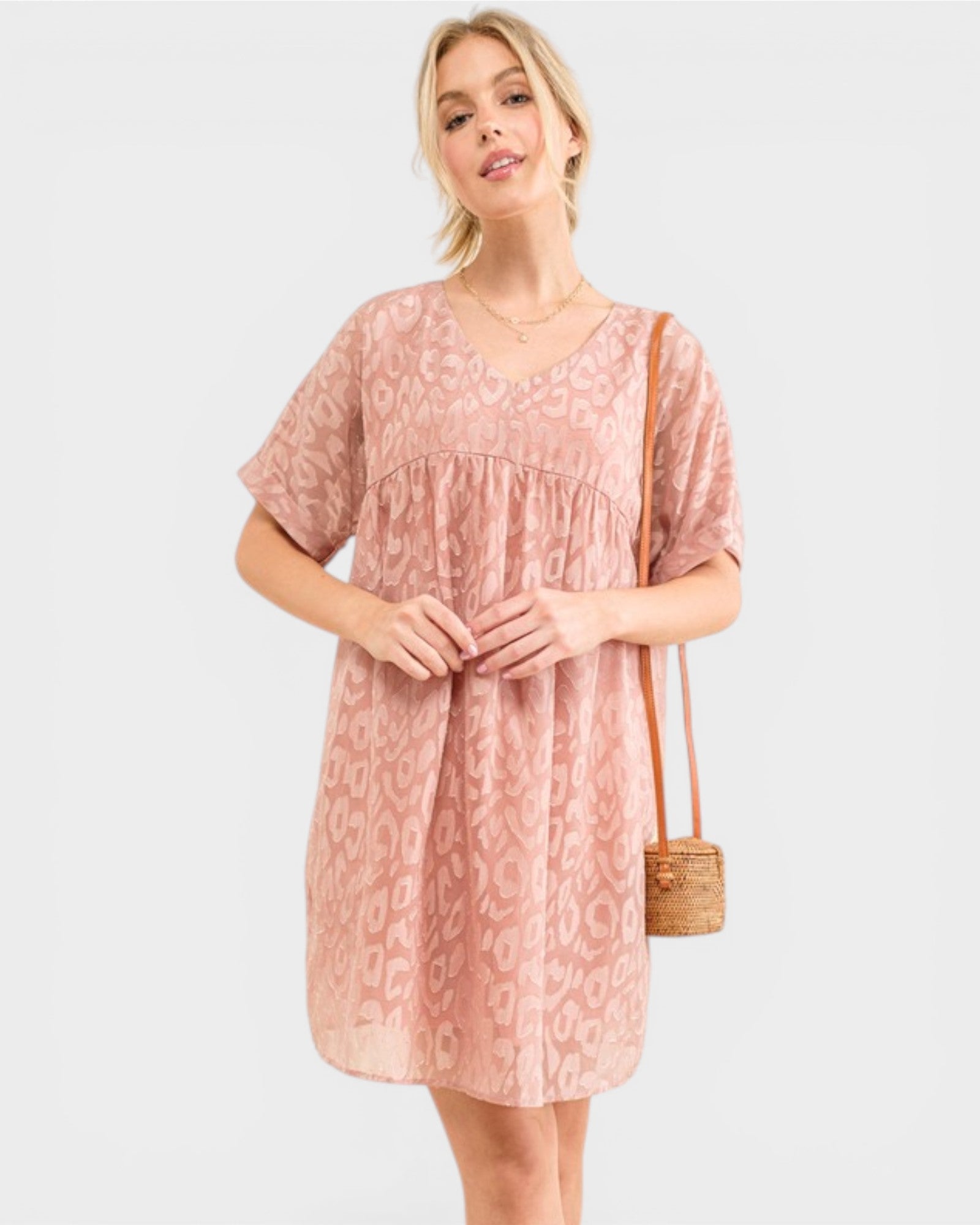 Woman wearing a pink patterned dress with a white background