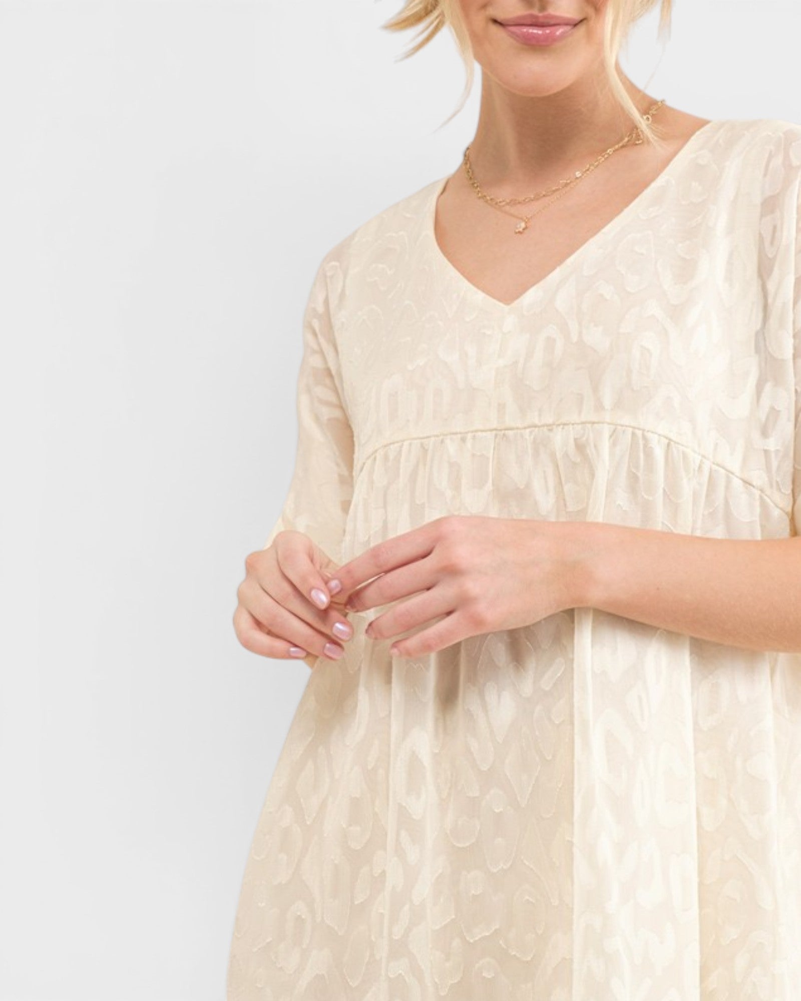 Woman wearing a beige dress with a plain background