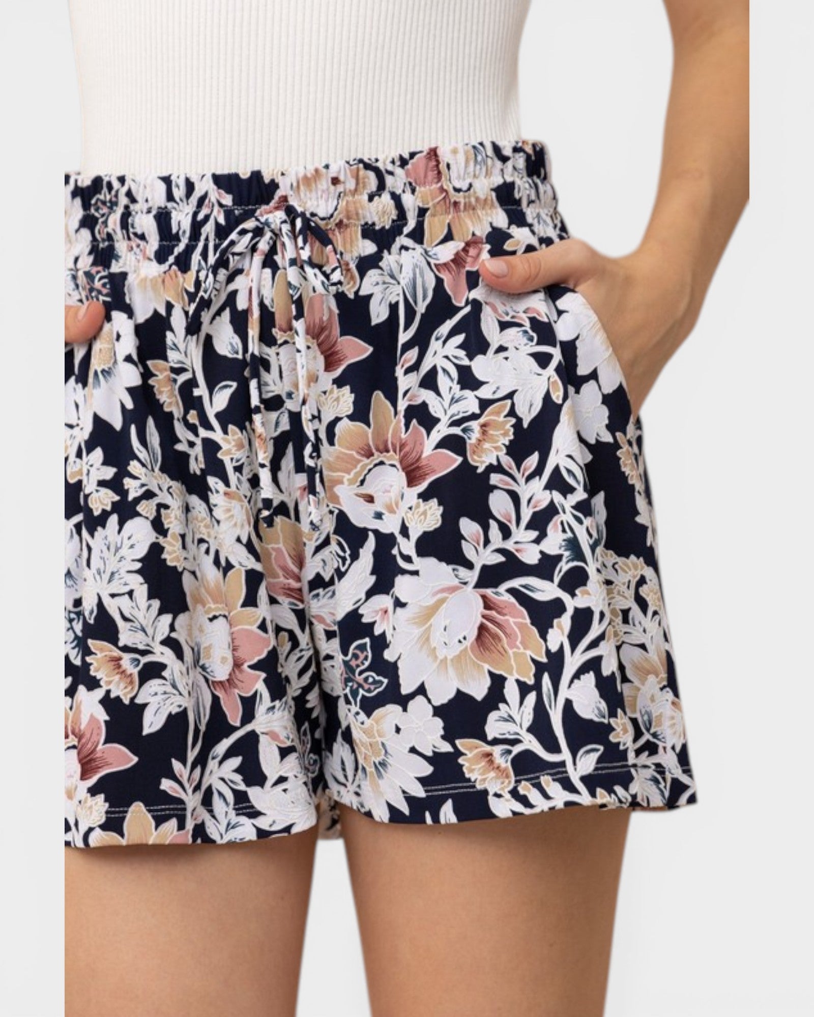 Floral shorts worn by a person on a plain background