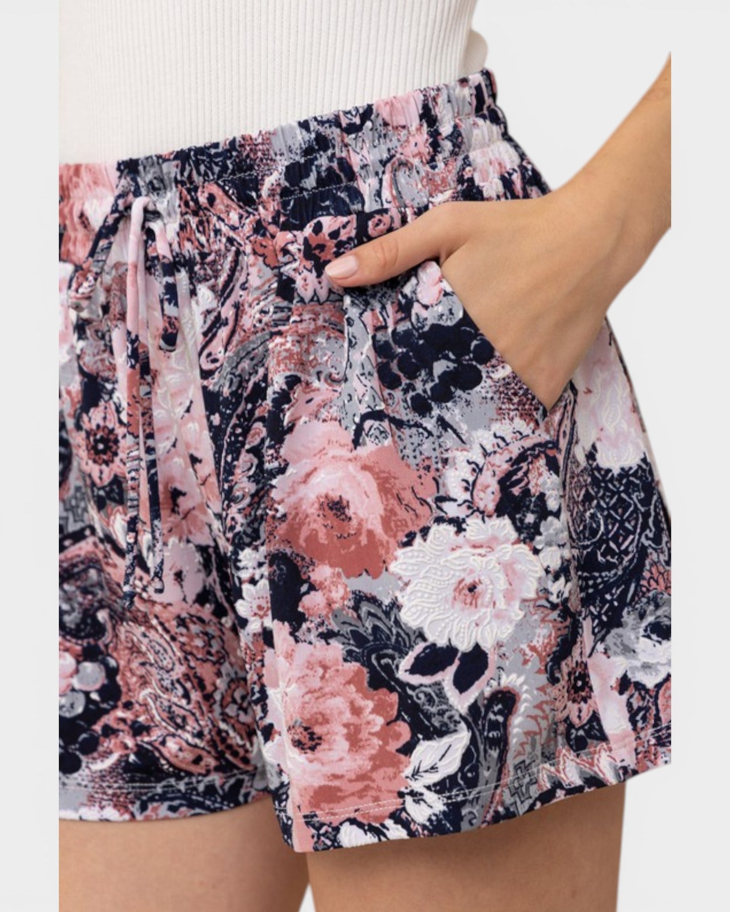 Floral patterned shorts being worn with a neutral background