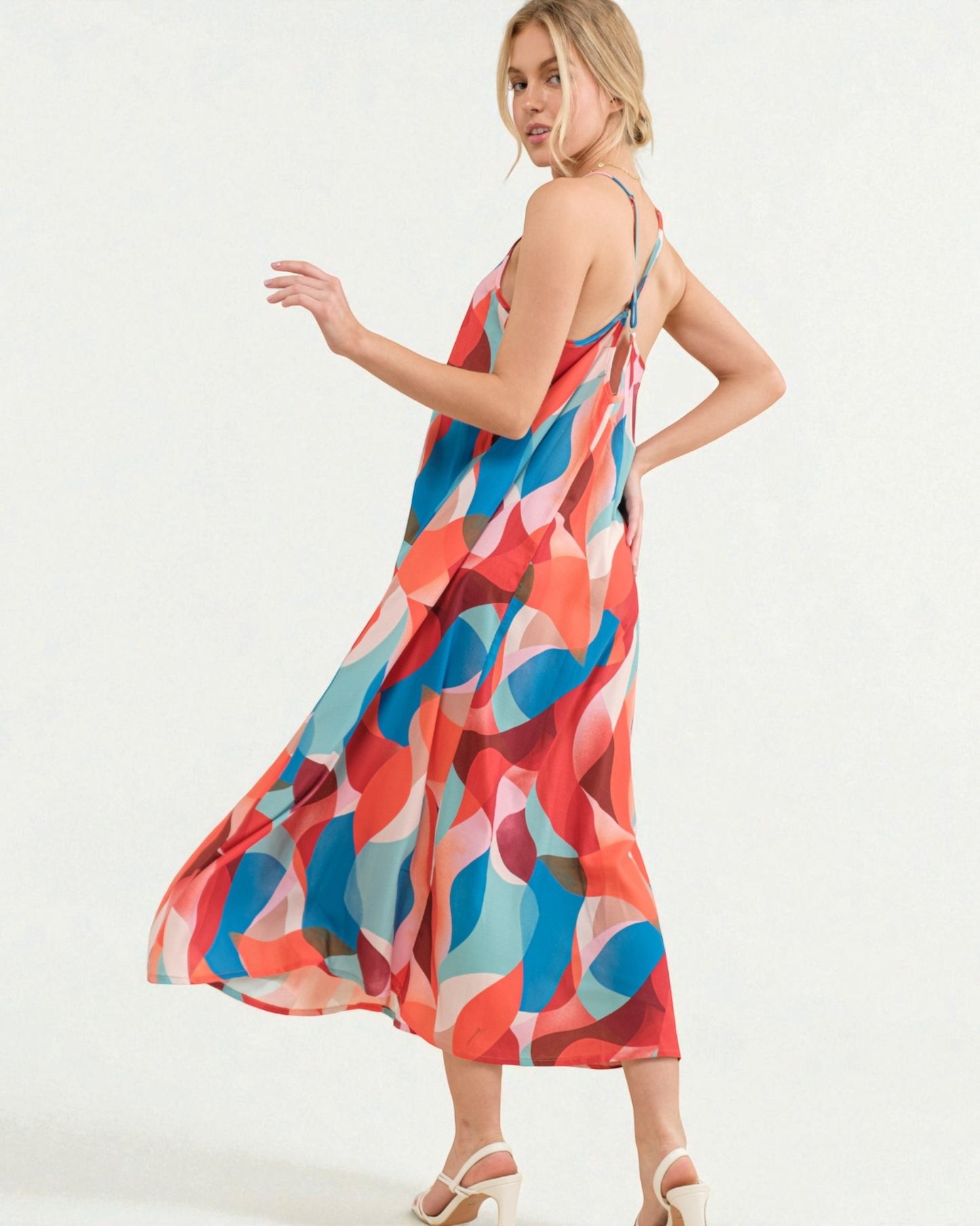 Woman wearing a colorful dress with abstract pattern on a white background