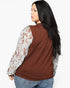 A woman shown from the back wearing a brown knit top with white lace sleeves, paired with blue jeans, against a plain white background.