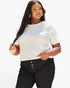 A woman modeling a white short-sleeve crewneck top paired with black high-waisted pants featuring three front buttons, set against a plain white studio background.