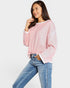 Woman wearing a pink sweater and blue jeans on a white background