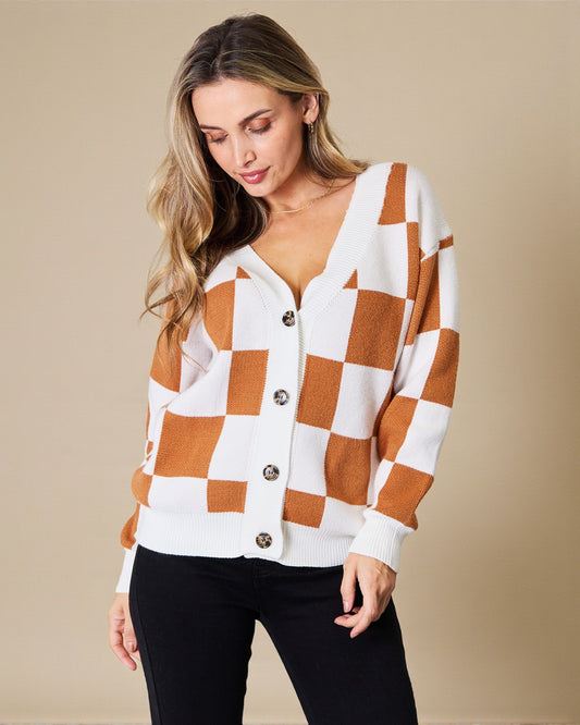 Woman wearing a checkered cardigan with a beige background