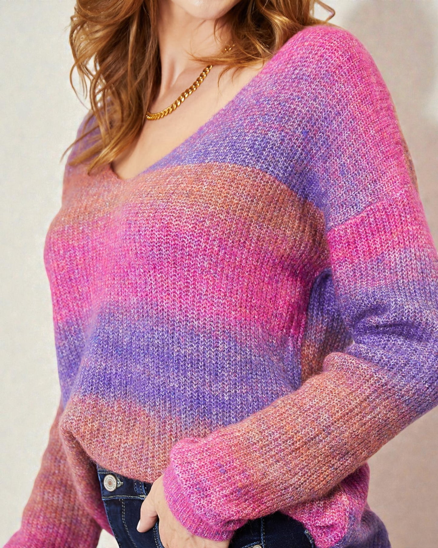 Person wearing a colorful sweater with a gradient of pink and purple.