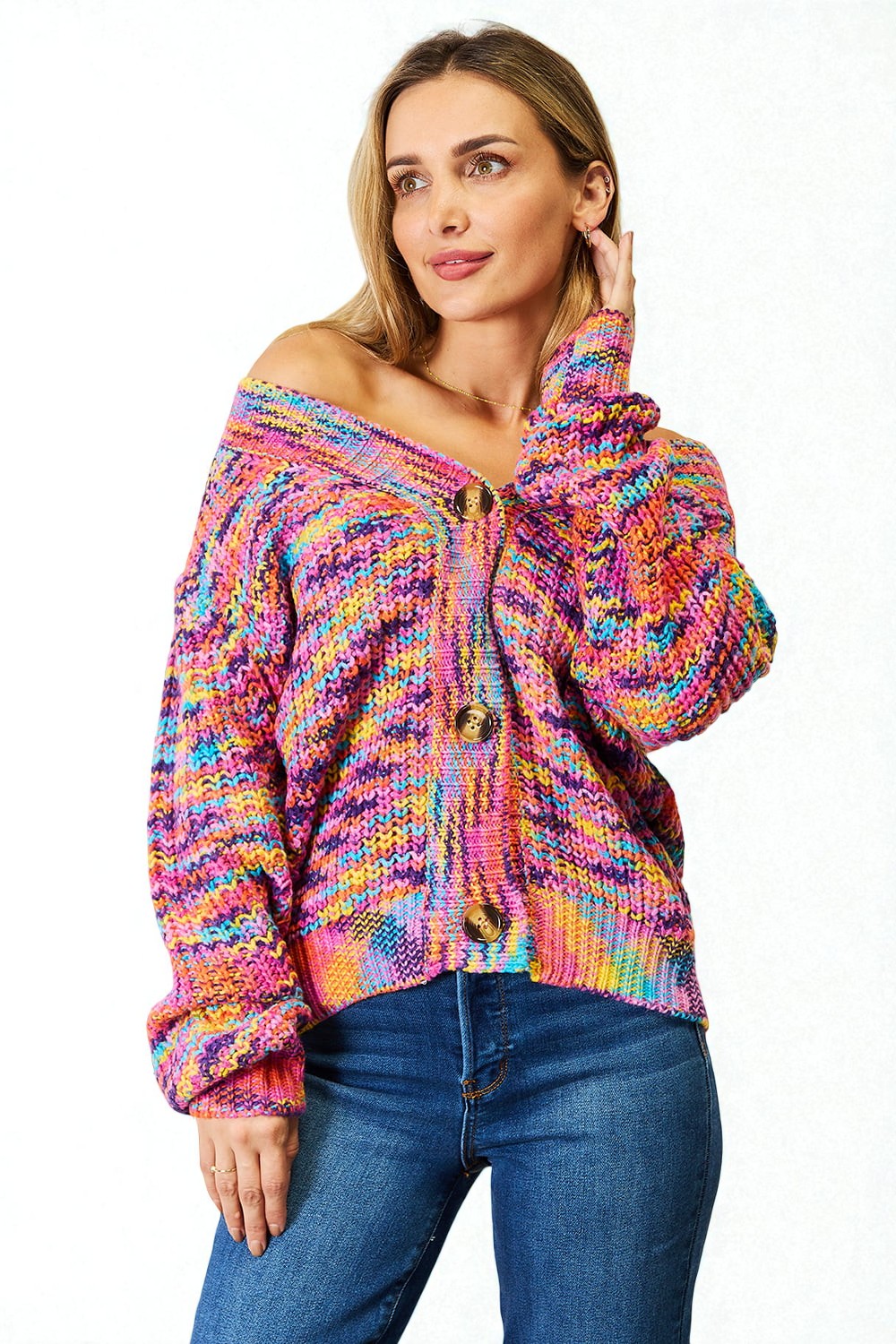 Woman wearing a colorful knitted sweater and blue jeans on a white background