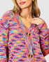 Multicolored knitted cardigan worn by a person on a light gray background