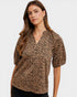 Woman wearing a leopard print blouse against a white background