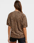 Person wearing a leopard print shirt on a plain background