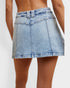 Light blue denim skirt worn by a person on a white background